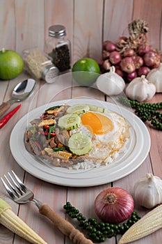 Holy Basil Fried Rice with Chicken Heart and Fried Egg on a White Wooden Floor