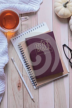 Holy bible and autumn cozy top view on wooden background. Bible study autumn concept