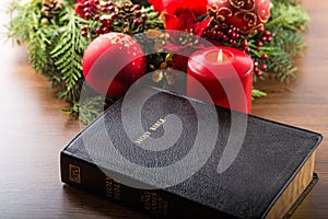 Holy bible with a big red candle and Christmas