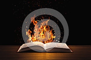 Holy Bible on fire on a wooded desk photo