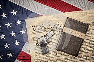 Holy bible and gun on constitution and American Flag