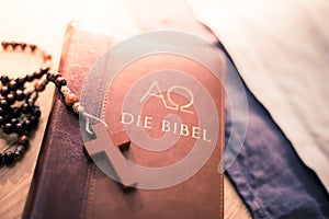 Holy bible and rosary: Christian bible and rosary on a wooden desk photo