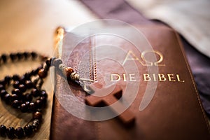 Holy bible and rosary: Christian bible and rosary on a wooden desk photo