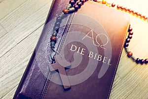 Holy bible and rosary: Christian bible and rosary on a wooden desk photo
