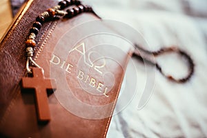 Holy bible and rosary: Christian bible and rosary on a wooden desk photo