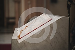 Holy bible on table during a wedding ceremony nuptial mass. Religion concept. Catholic eucharist ornaments for the celebration of