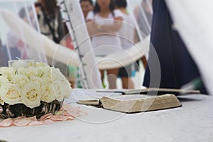 Holy bible and wedding bouquet at wedding on beach