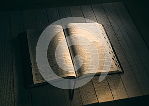 Holy Bible on a wooden table  in a dark room