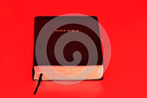 Holy Bible, the Word of God. Isolated on red background. Top view