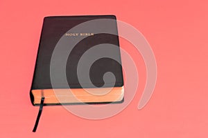 Holy Bible, the Word of God. Isolated on red background. Top view. Copy space