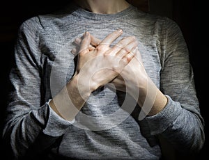 Hands folded in prayer over the heart photo