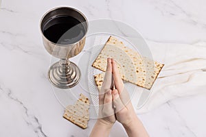 Holy communion chalice with wine and bread. Lord`s supper and hands folded in prayer