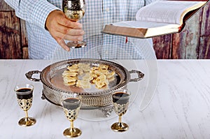 Holy communion on wooden table in church cup of glass with red wine, bread, prayer for wine