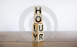 Holy hour symbol. Turned wooden cubes with words holy hour. Beautiful wooden table, white background, copy space. Religion and