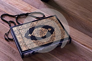 Holy islamic book Quran on the wodden board with a rosary - Ramadan kareem/Eid al fitr Concept.
