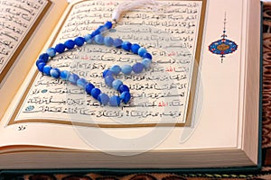 The Holy Koran page with blue rosary