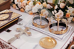 Holy matrimony in church. Golden crowns,cross,bible and candles