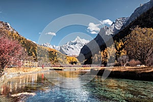 The holy mountain with emerald lake in autumn forest at Yading