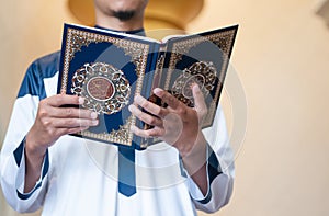 Holy Quran in Hand. Muslim man holding Quran