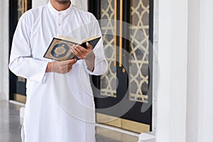 Holy Quran in Hand. Muslim man holding Quran