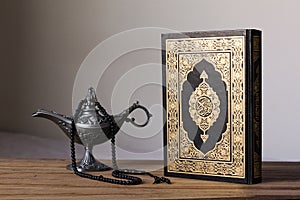Holy Quran on the wodden background with a rosary and Egypt aladdin lamp -Ramadan kareem/Eid al fitr Concept