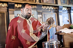 Holy water consecration in orthodox church. Religious priest during service photo