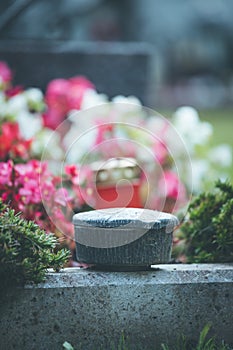 Holy water in iron bowl, cemetery, flowers