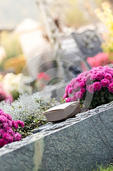 Holy water in iron bowl, cemetery, flowers