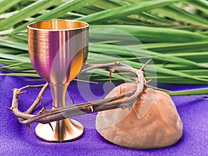 Holy Week, Lent, Palm Sunday, Maundy Thursday, Good Friday, Easter Sunday Concept. Chalice, Crown, bread and palm leaf background.