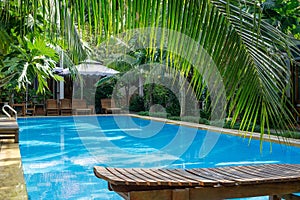 Holz-Sonnenliegen um einen Pool in einer Hotelanlage mit Villen auf der Insel Phu Quoc in Vietnam photo