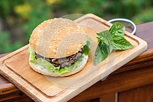 Homamade beef or pork hamburger with vegetable on chopping board with basil leaf in garden, food photoraphy