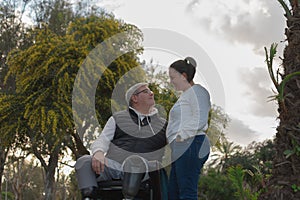 hombre en silla de ruedas posa junto a su esposa photo