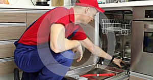 Home appliance maintenance service - repairman working with dishwasher