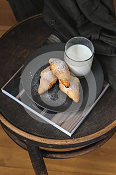 Home baked croissants and a glass of milk served on a vintage chair