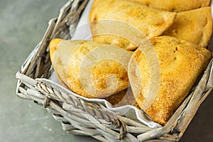 Home Baked Empanadas Turnover Pies with Pisto Vegetable Cheese Filling in Tomato Sauce in Wicker Basket. Spanish Pastry