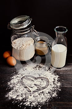 Home baking. Baking with love. Baking ingredients and heart of flour on the wooden table