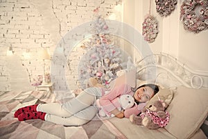Home is the best place in the world. Girl little kid relaxing on bed light interior with christmas decorations