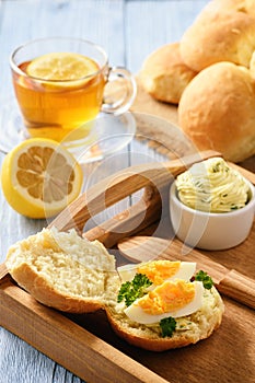 Home breakfast - homemade bread rolls, cup of tea, boiled eggs and garlic herb butter.