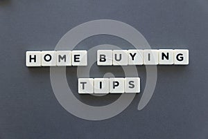 Home buying tips word made of square letter word on grey background.