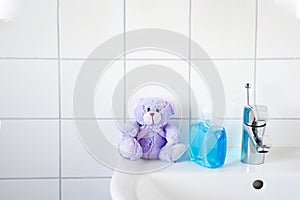 Home care image bathroom washbaisn ,tab water with a bottle blue  alcohol gel  sanitizers for washing hand and bear toy  for