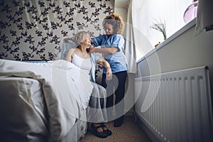 Home caregiver dressing senior