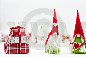 Home Christmas decoration on white background. Christmas fir branches, gift boxes with red ribbon, red decoration, sparkles and