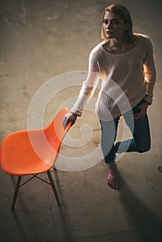 Home comfort with girl at chair. thoughtful woman at home with orange chair. lazy day at home. Frustrated woman standing