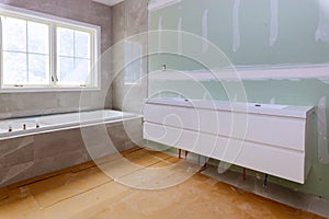 Home construction bathtub tiled walls after installing remodeling master bathroom patching drywall