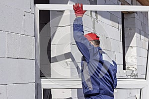 Home construction loader worker carries a platic window for installation