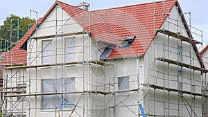 Home construction.New house with red roof in scaffolding.Building materials and the process of building a new house