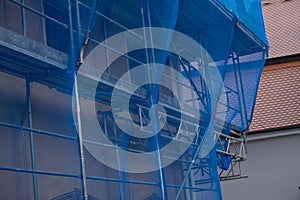 Home construction. Scaffolding in a protective blue grid. building work. Home construction.Building materials and the