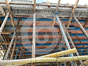 Home construction with wooden scaffolding from bottom view under cloudy sky