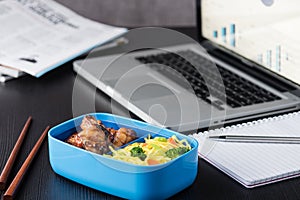 Home cook bento box during office lunch with computer laptop