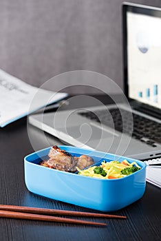 Home cook bento box during office lunch with computer laptop